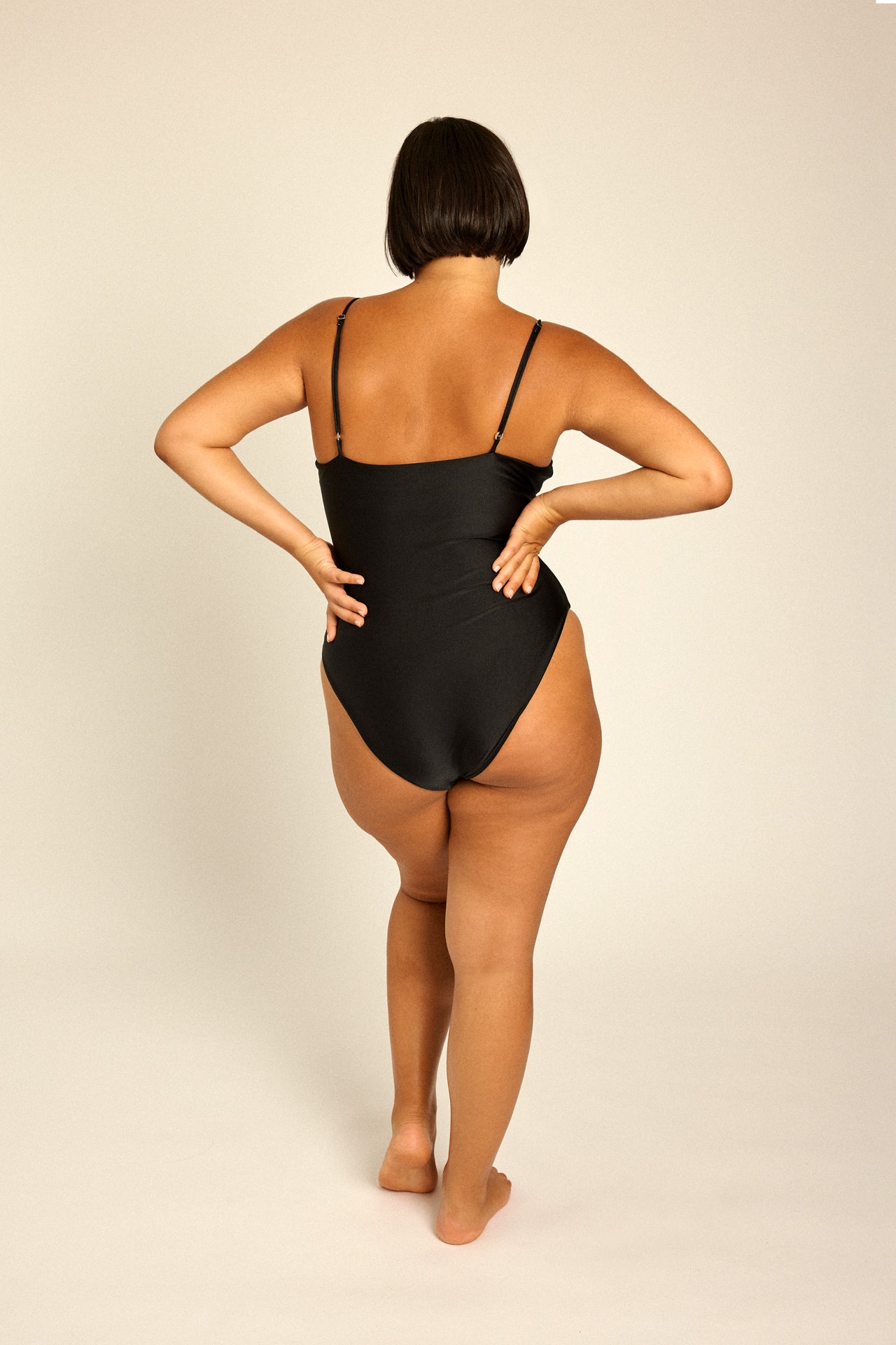 Curvy model in plus size XL swimsuit for summer beach.